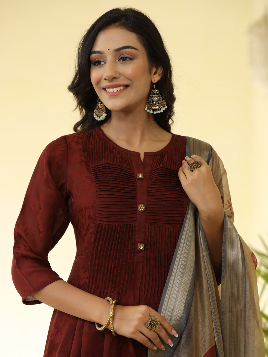 Brown Silk Pleated Straight Kurta Has Round Neck, Front Placket And Buttons With Both Side Pleats, Three Fourth Regular Sleeves, Flared Hemline, Cotton Mulmul Lining Is Attached To Kurta, Brown Pants Has Both Side Pocket And Partially Elastic Waist, Organza Printed Dupatta.